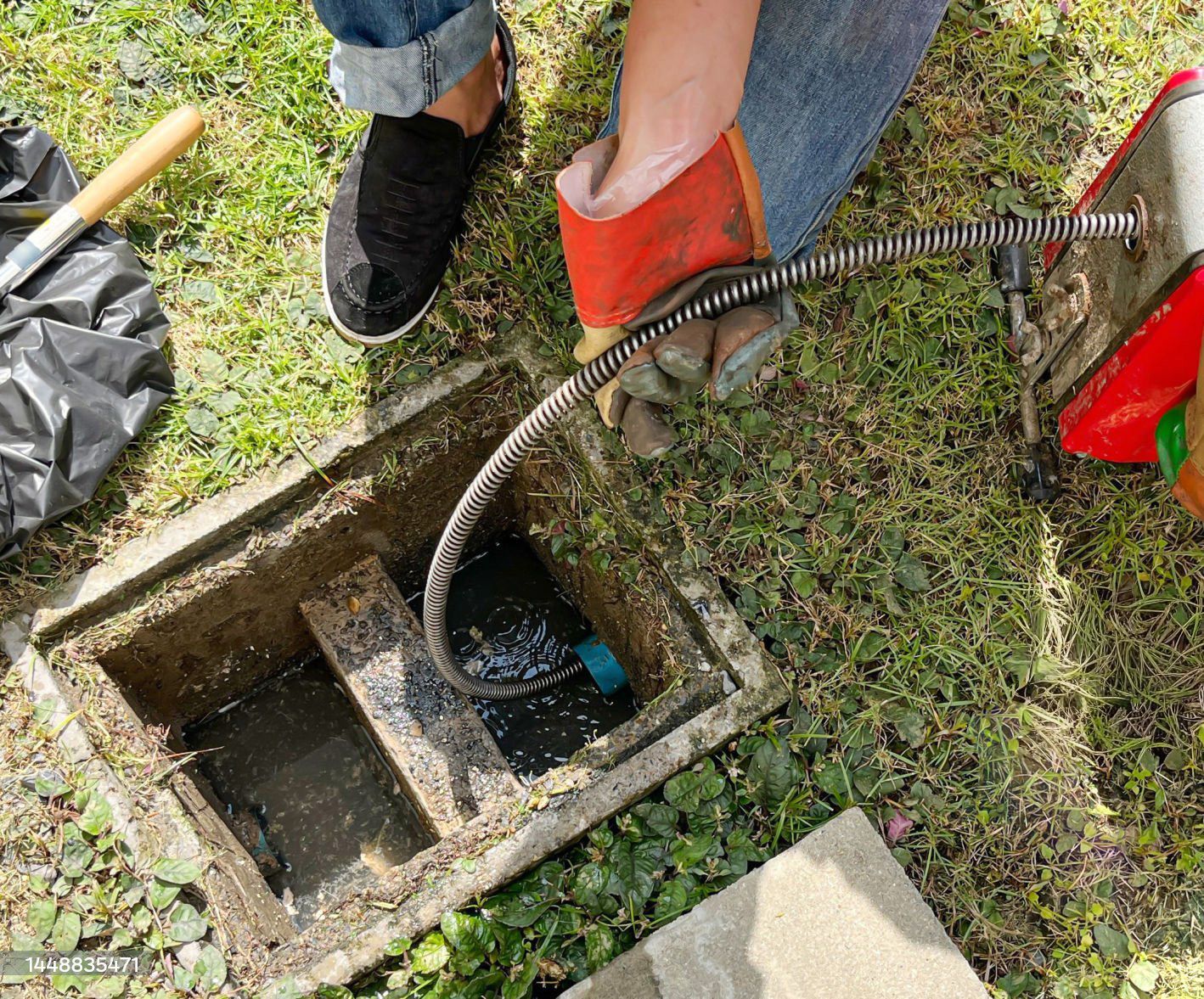 A man is fixing a sink with a wrench.