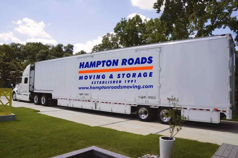 Hampton Roads Moving & Storage moving truck parked outside a home with company branding displayed on the trailer.