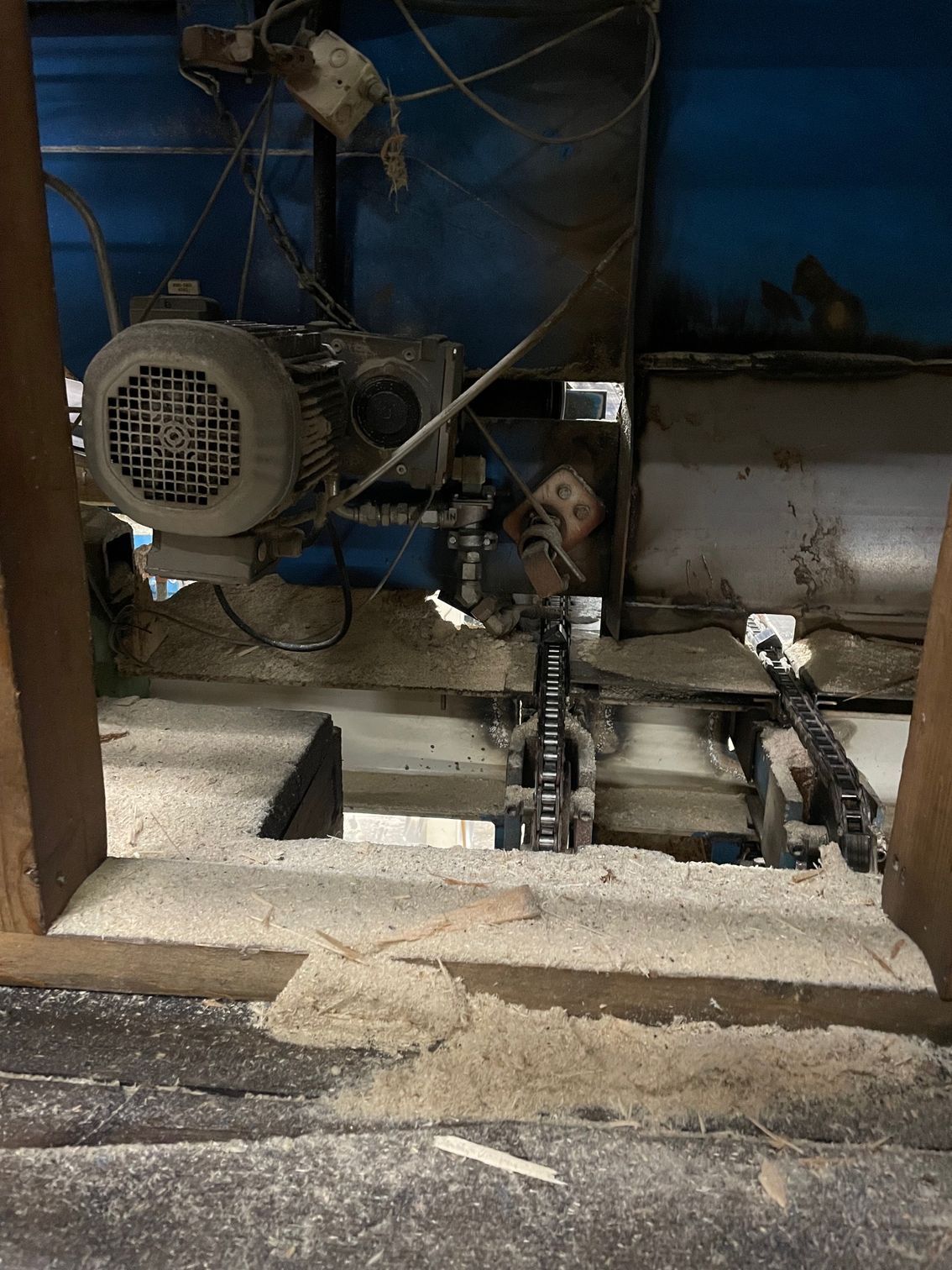 Industrimaskiner på ett betonggolv, med en motor, rör och metallutrustning i ett dunkelt grovkök.
