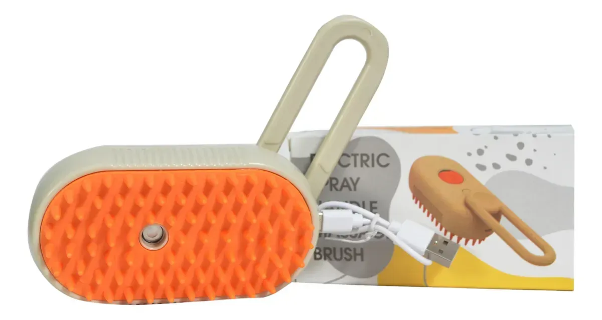 Cepillo pulverizador eléctrico en color naranja y beige con cable USB, sobre caja blanca estampada.