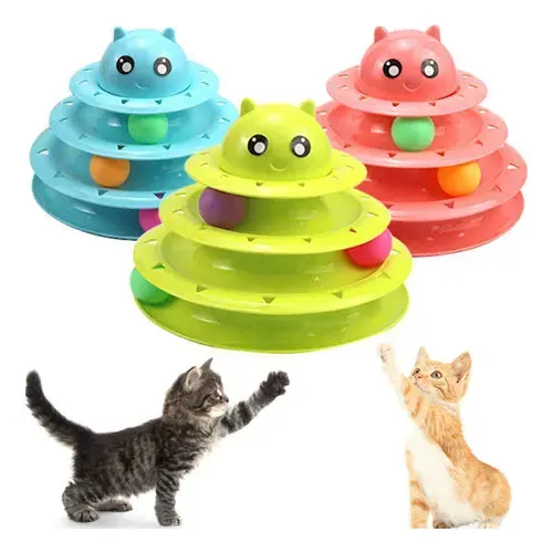 Un gatito jugando con una torre de juguetes rosa para gatos con bolas de colores.
