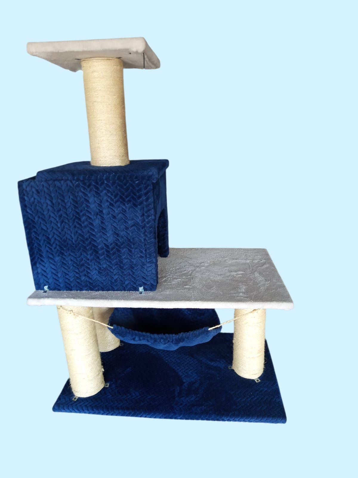 Árbol para gatos de color azul y gris con múltiples plataformas, postes rascadores y hamaca sobre fondo azul claro.