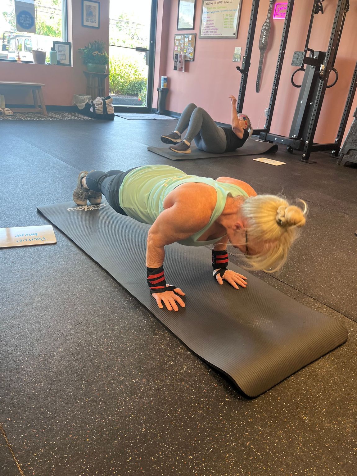 Woman doing a plank on a gym mat in a fitness studio