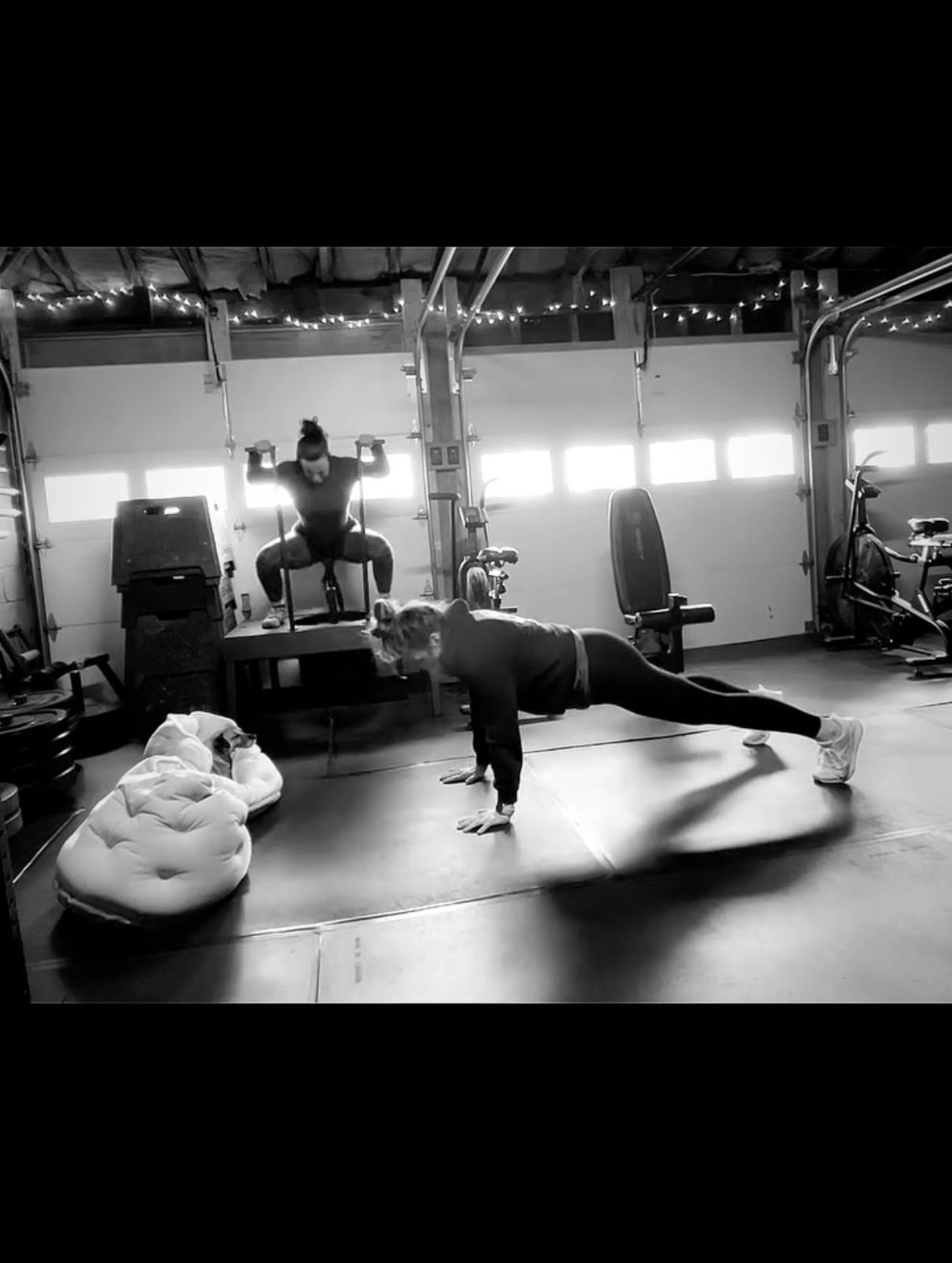 Person doing a plank in a gym, with exercise equipment and a punching bag in the background.