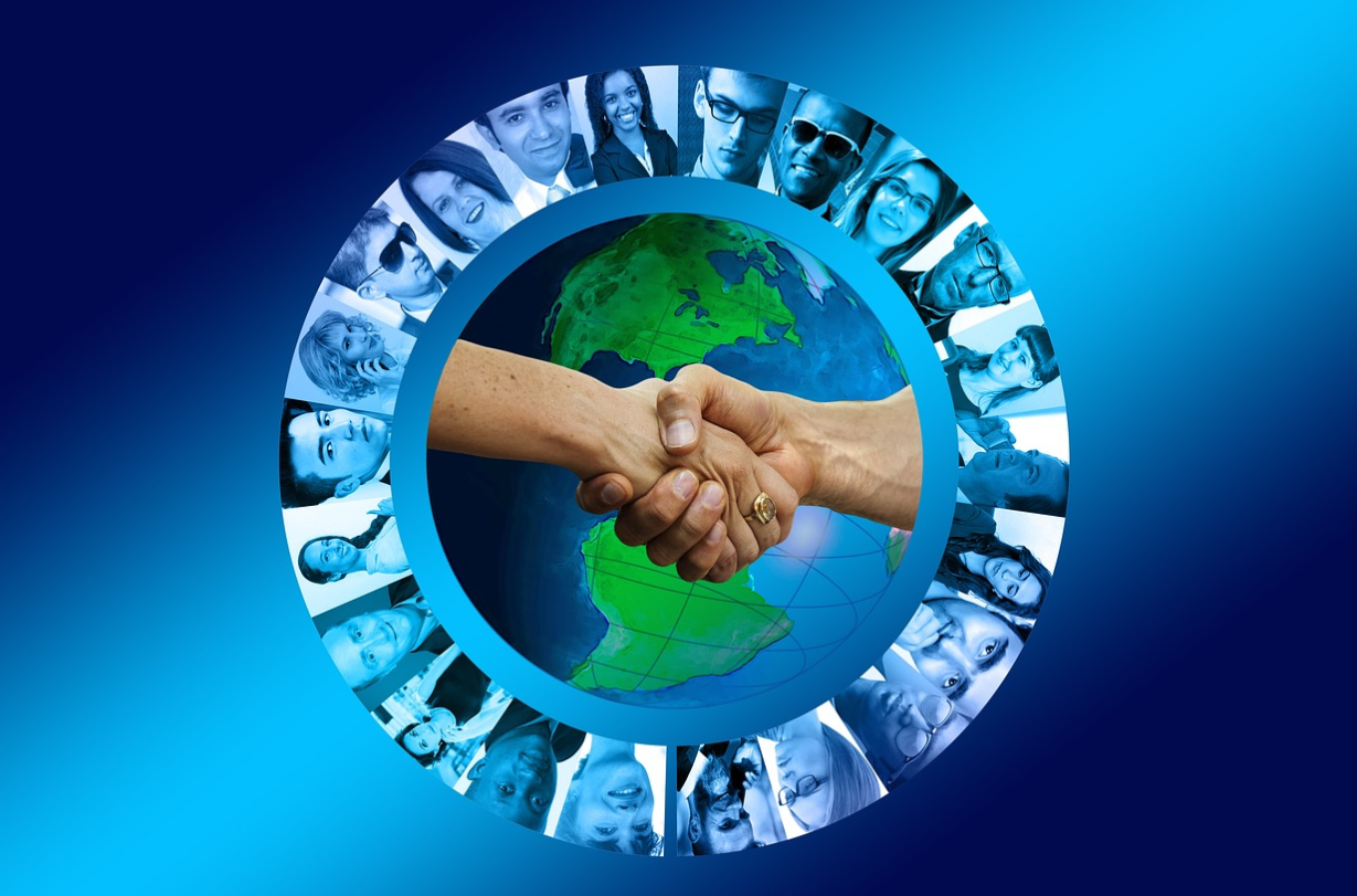 Two people shaking hands in front of a globe