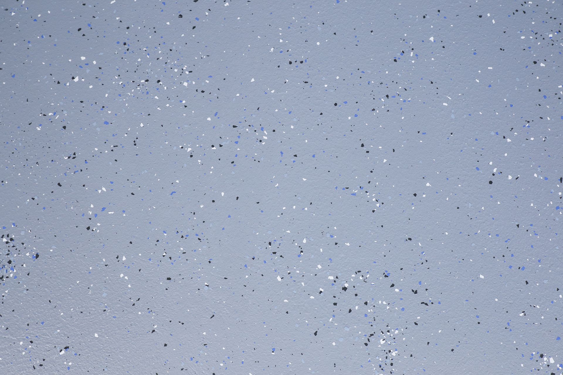 Light blue-gray speckled surface with scattered dark flecks
