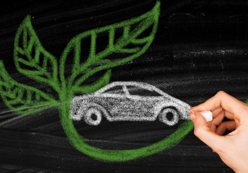 Hand drawing of a silver eco car with green leaf-shaped wings on a chalkboard
