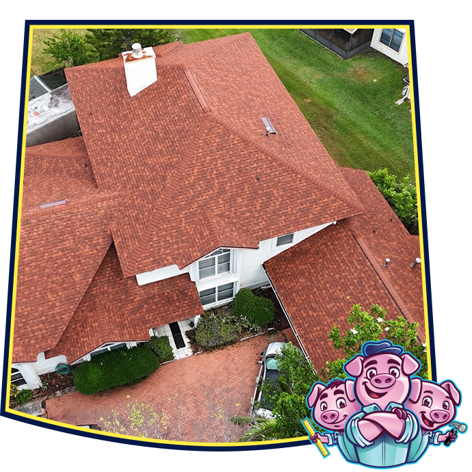 Aerial view of a house with a red roof, featuring a cartoon logo of three smiling pigs in the bottom right corner.