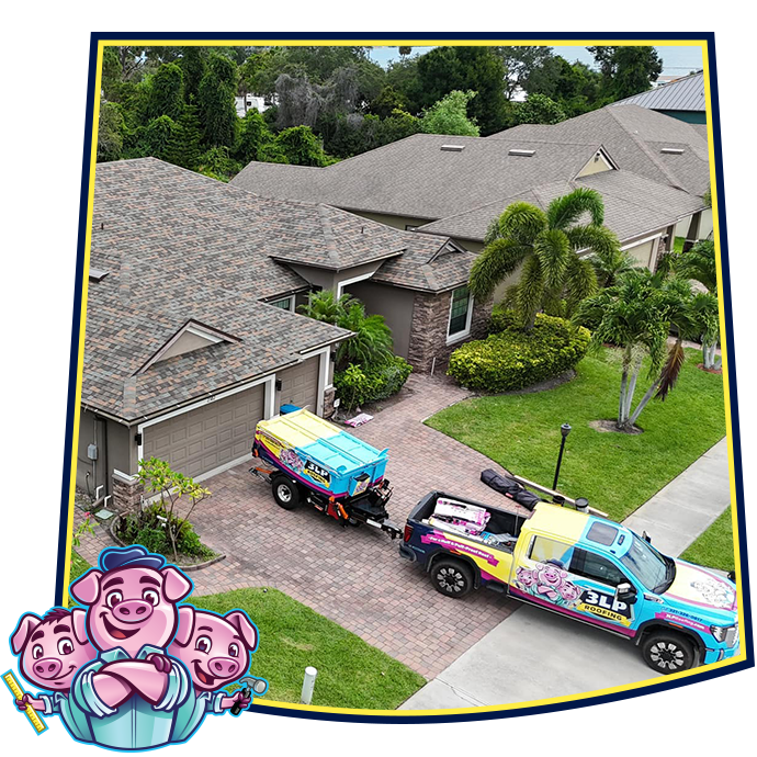 A brightly colored JLP Pressure Washing truck tows a trailer in the driveway of a suburban home.