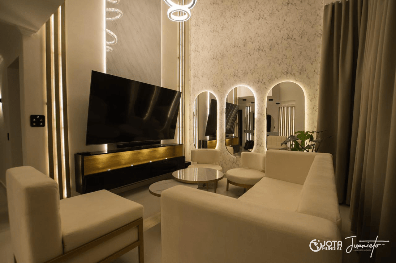 Una sala de estar con sofá, silla, mesa y televisión.