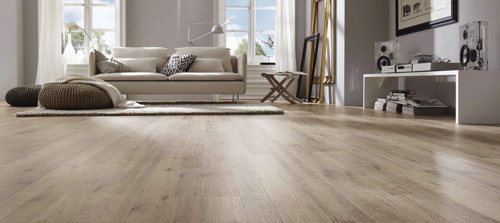 Una sala de estar con suelo de madera y un sofá.