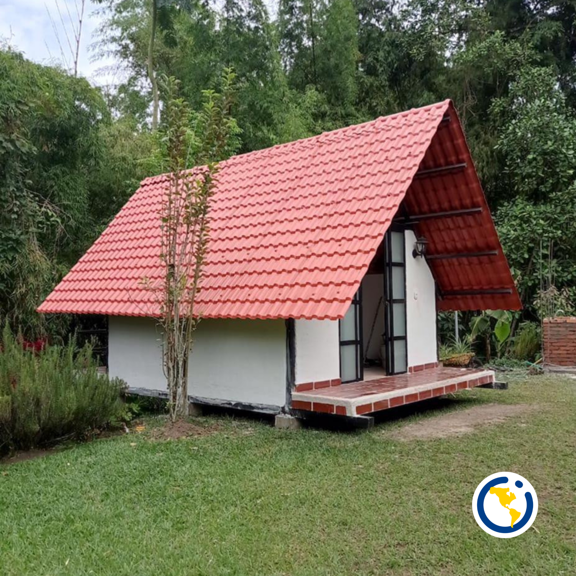 Una pequeña casa blanca con techo de tejas rojas