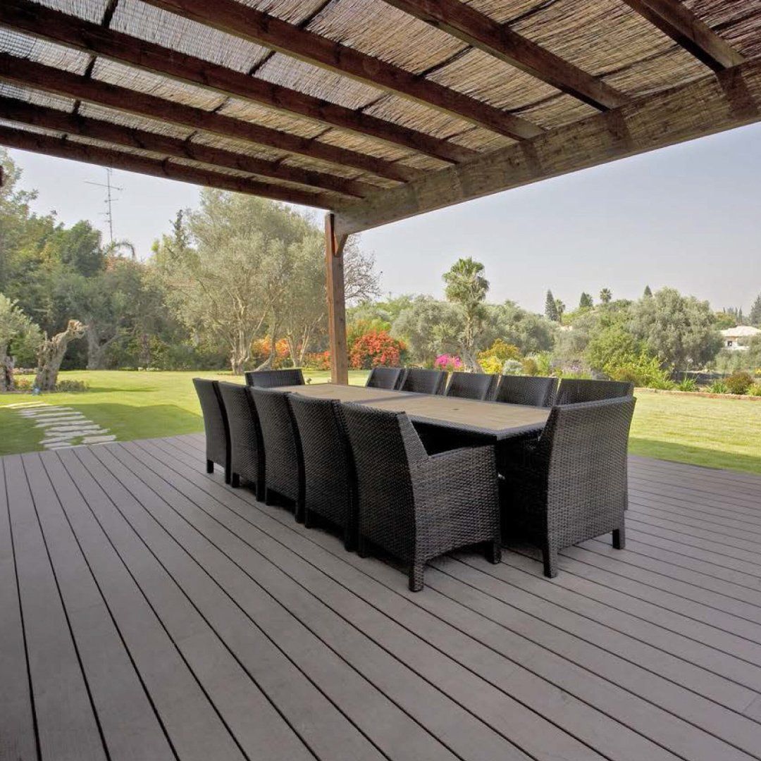 Un patio con una mesa y sillas bajo un dosel.