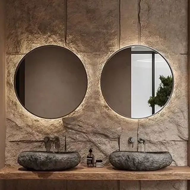 Un baño con dos lavabos y dos espejos.