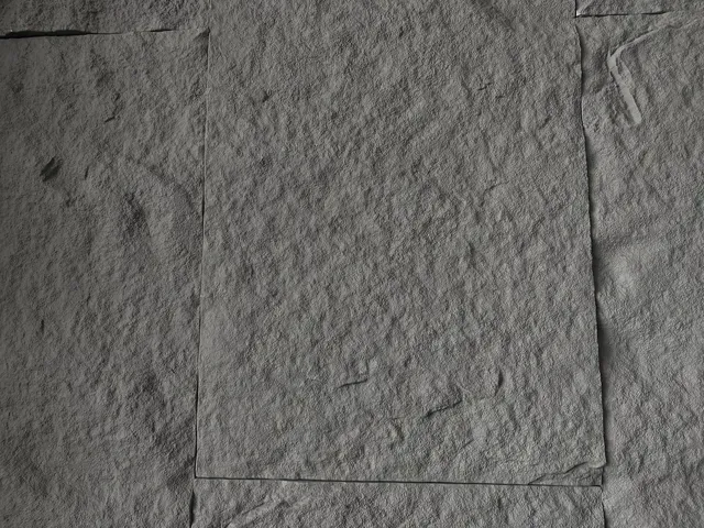 Un primer plano de una pared de piedra gris con un cuadrado en el medio.
