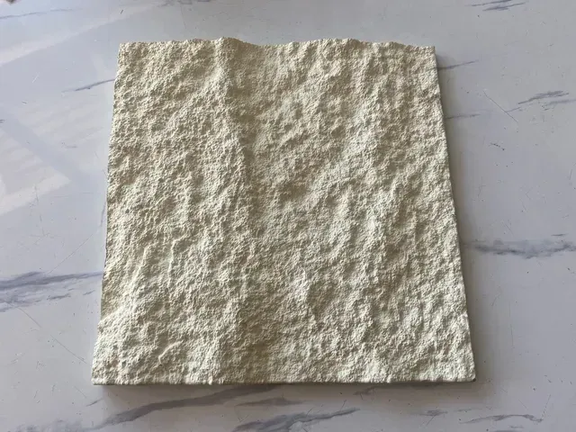 Un trozo de papel con una textura rugosa está sobre una mesa.