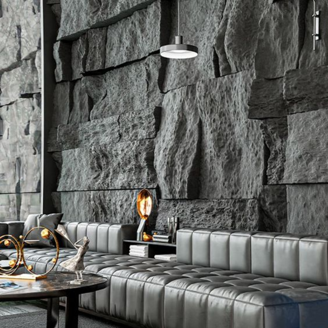 Una sala de estar con un sofá y una mesa frente a una pared de piedra.