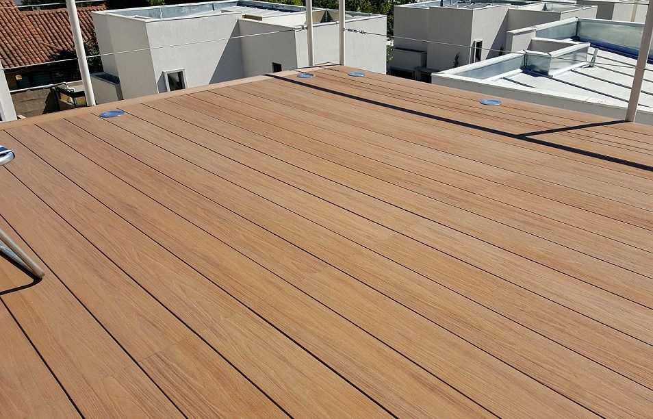 Una plataforma de madera en la parte superior de un edificio con edificios al fondo.