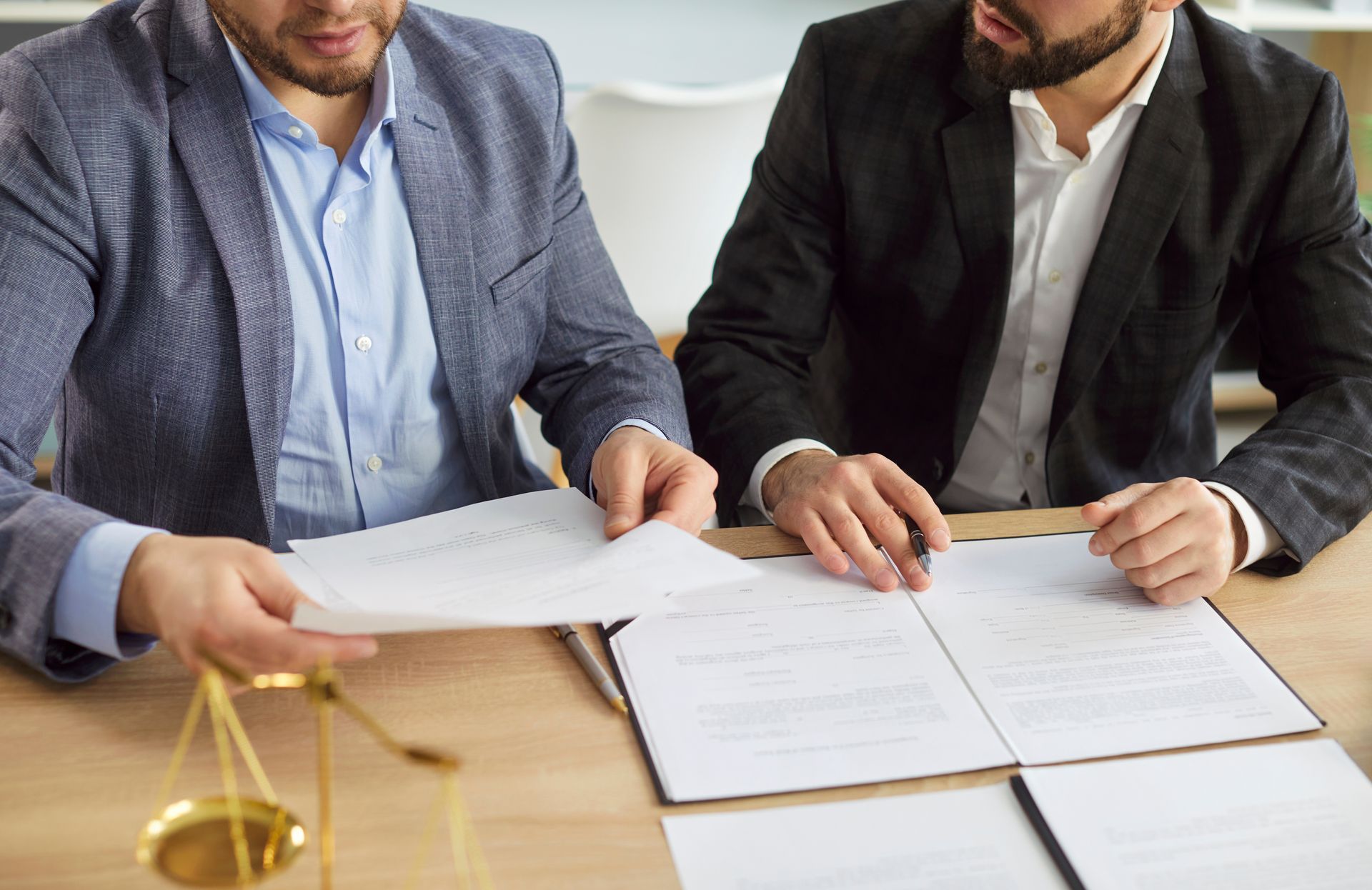 Divorce attorney reviewing legal documents with a male client during a men's divorce consultation Divorce attorney reviewing legal documents with a male client during a men's divorce consultation
