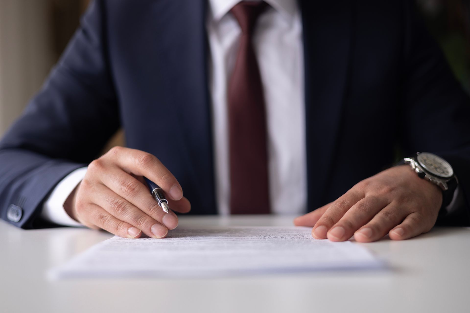 Man signing divorce papers with support from a divorce lawyer for men during a legal consultation.