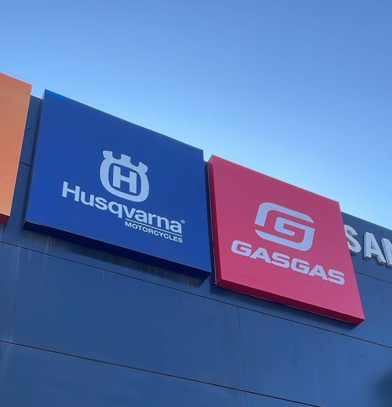 Un cartel de Husqvarna y Gasgas en el lateral de un edificio.