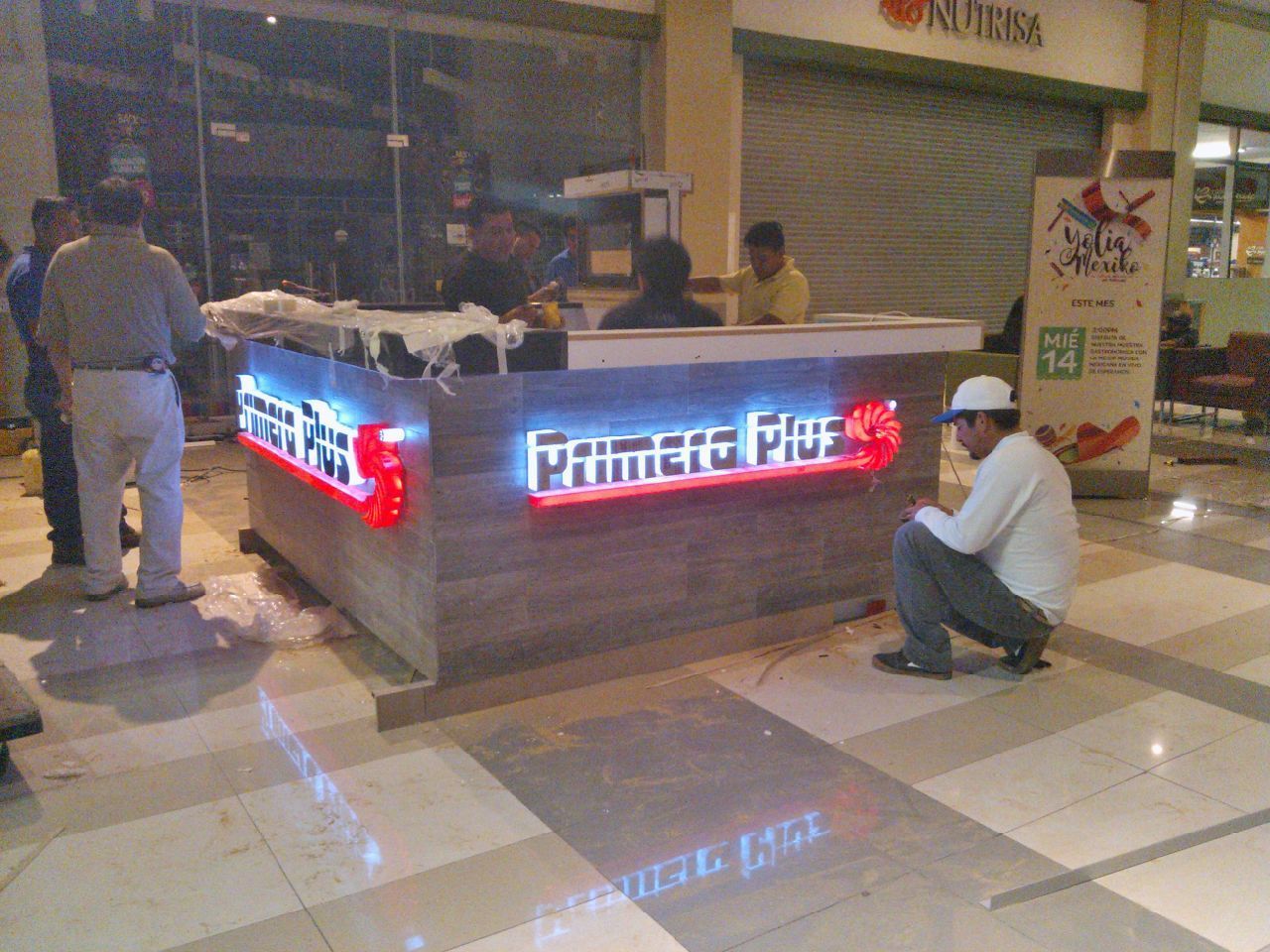 Un hombre está arrodillado frente a un cartel que dice primata plus