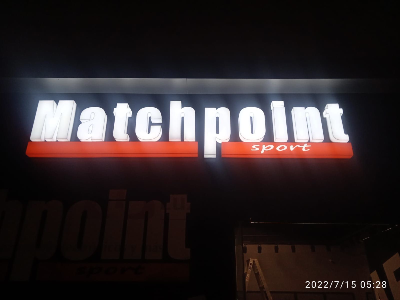 Un cartel para Matchpoint Sport se ilumina por la noche