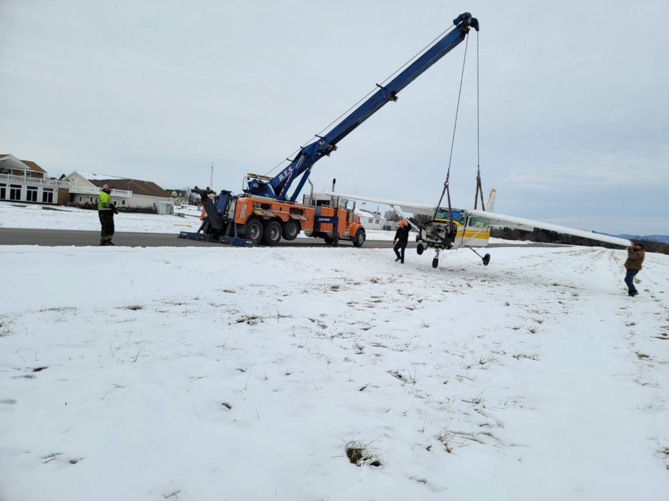 A white car is being towed by a tow truck.