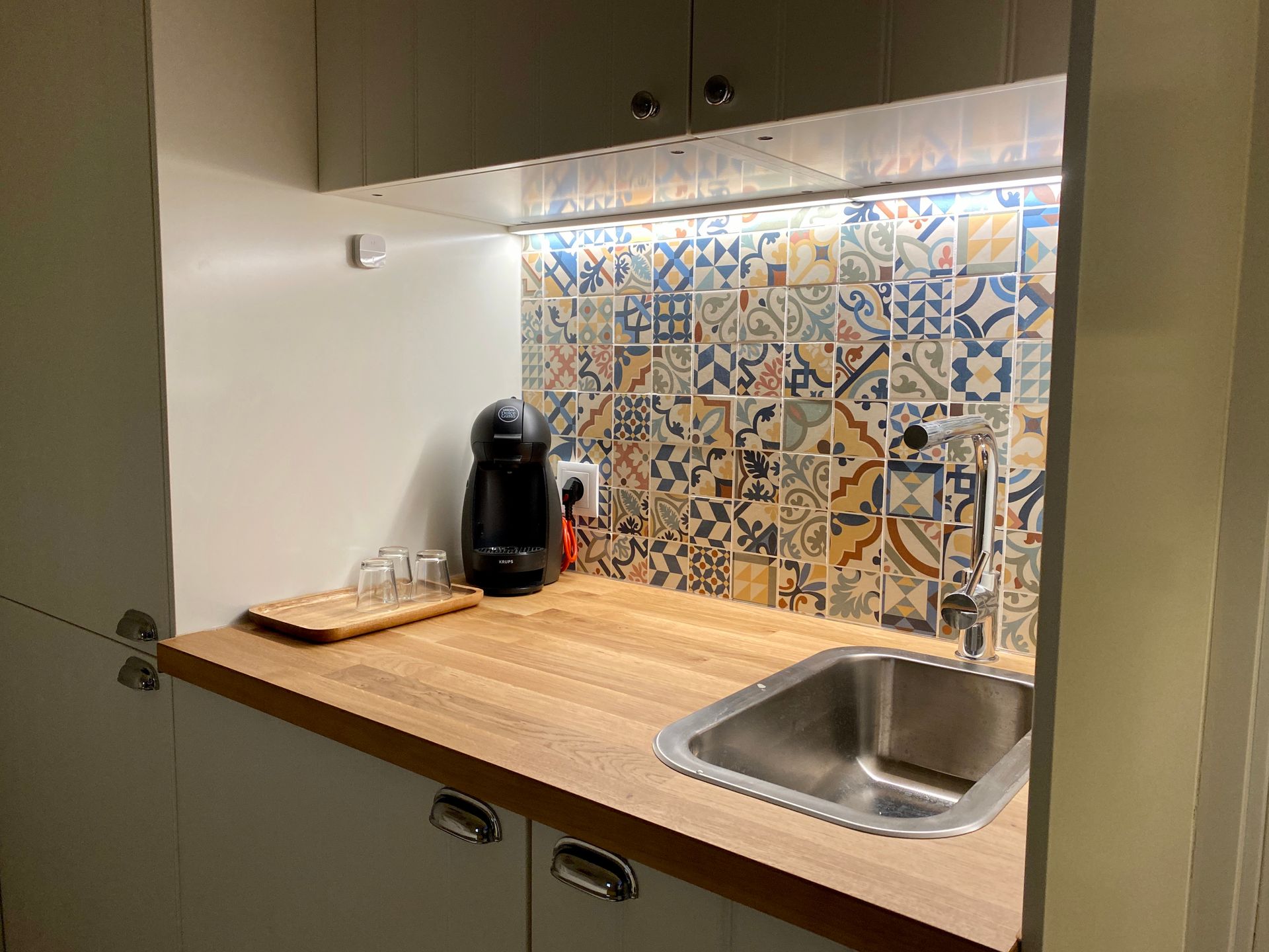 A kitchen with a sink and a coffee maker on the counter.