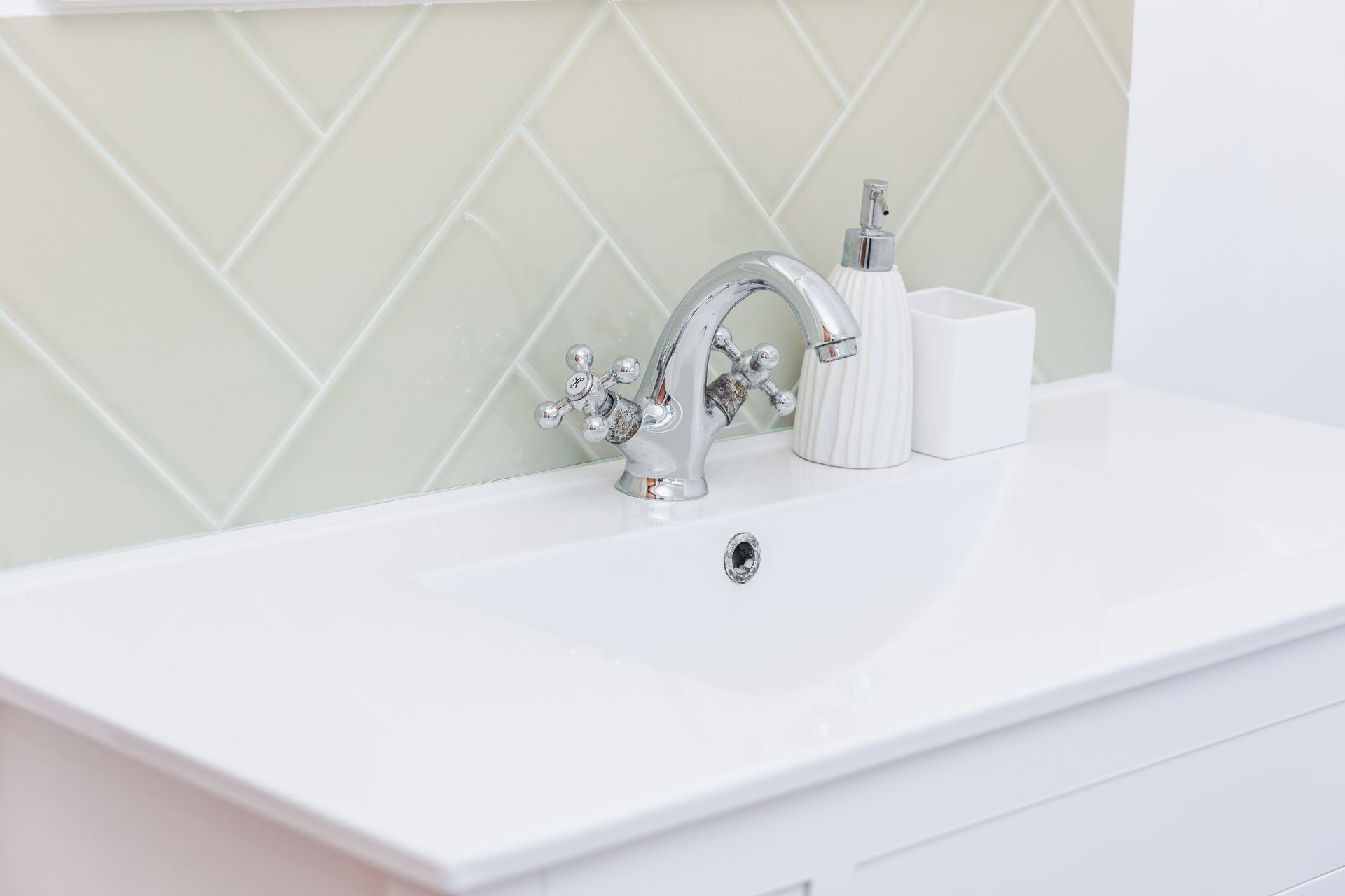 A bathroom sink with a faucet and soap dispenser on it.