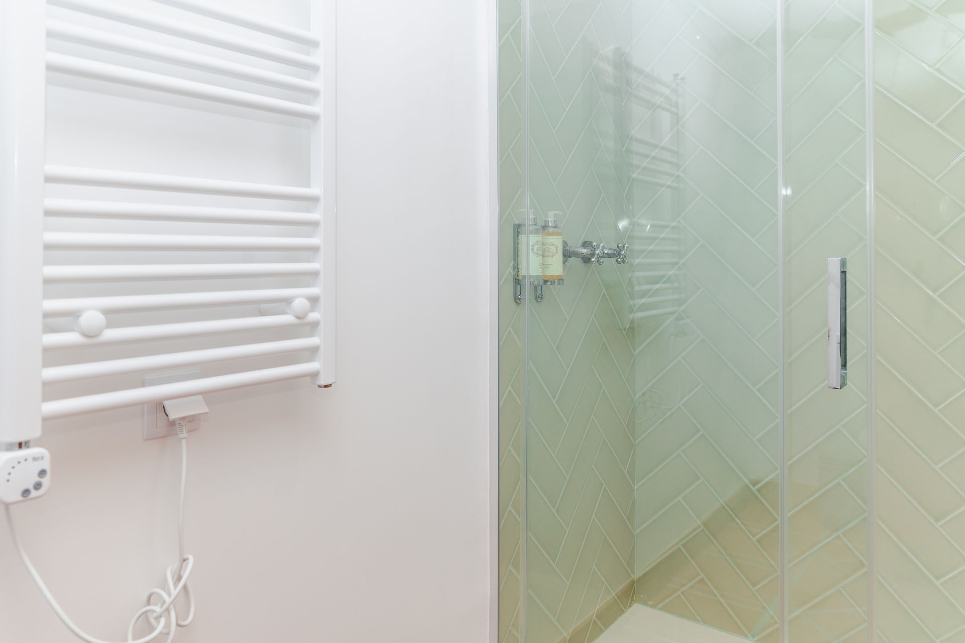 A bathroom with a towel rack and a glass shower door.