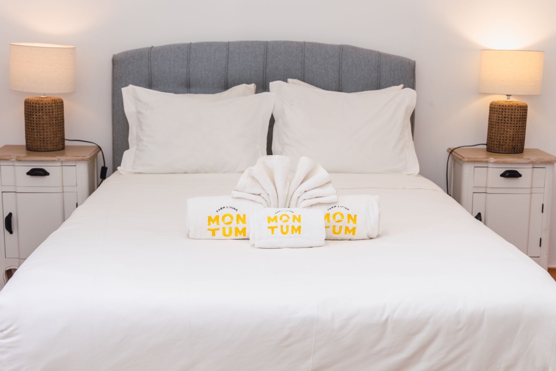 A bedroom with a bed , two nightstands , and two lamps.