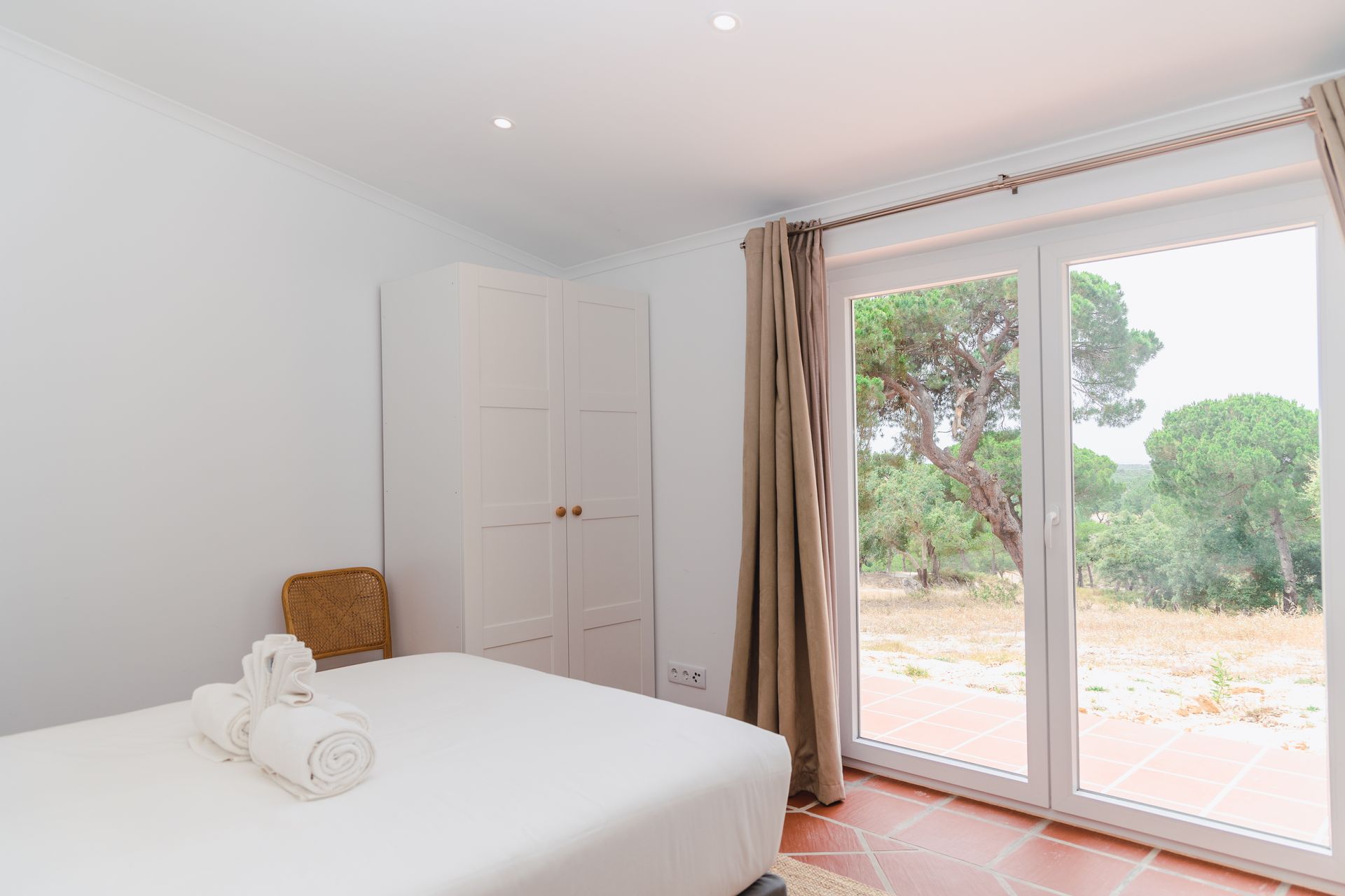 A bedroom with a large bed and a large window.