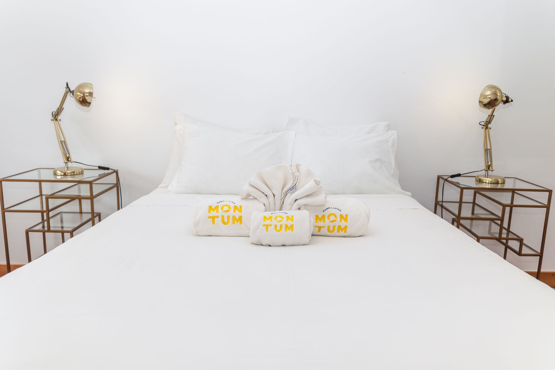 A bed with two nightstands next to it and two towels on it.