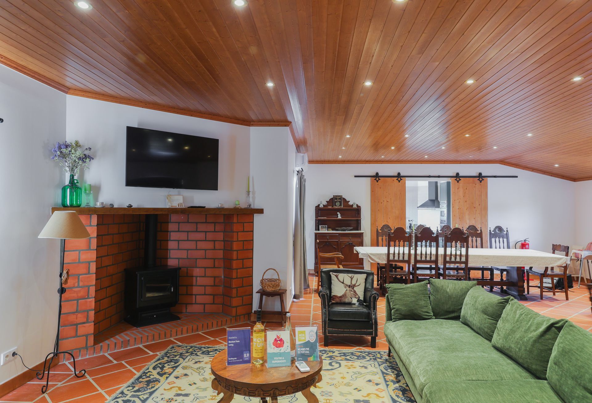 A living room with a green couch and a brick fireplace