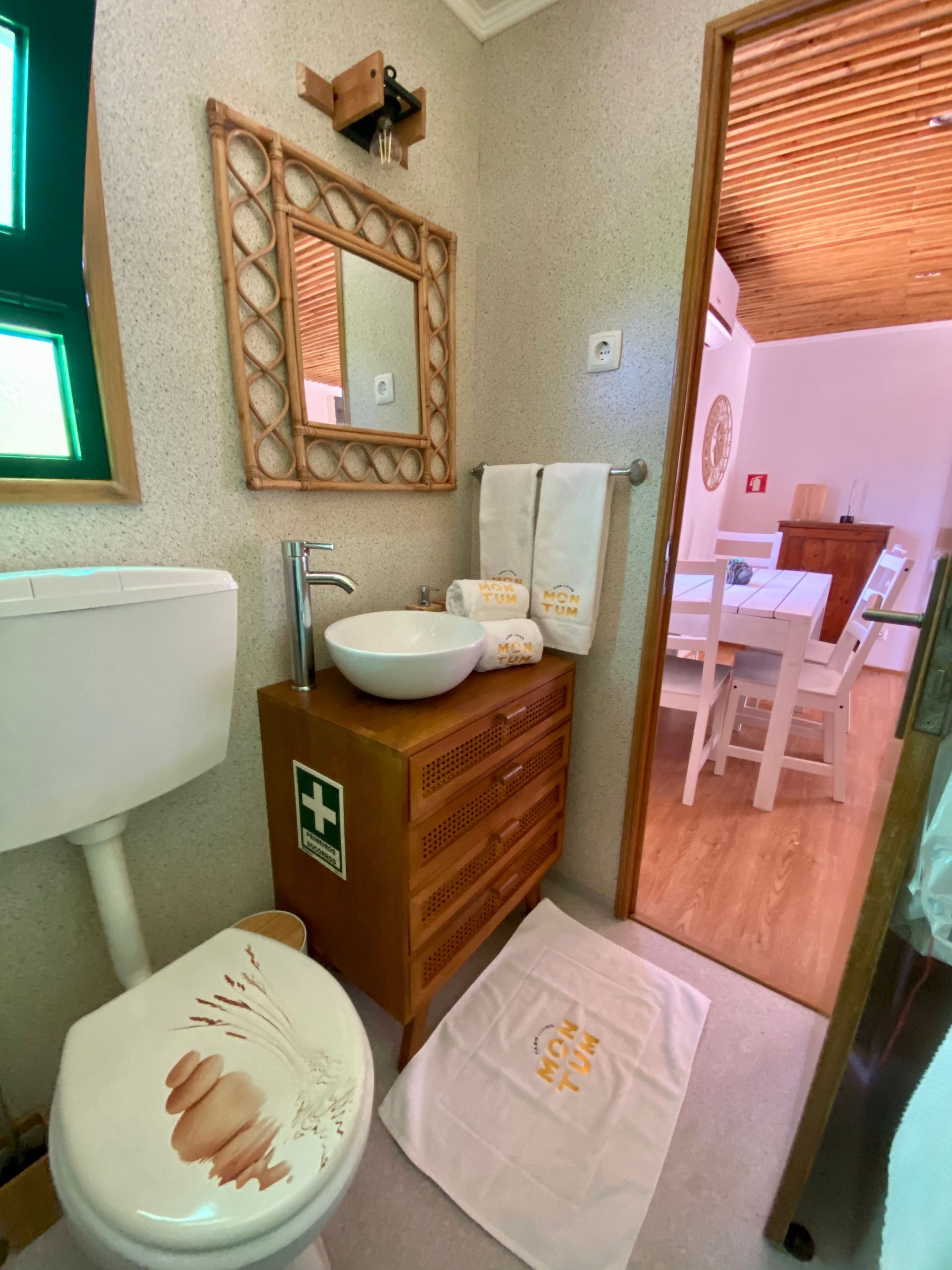 A bathroom with a toilet , sink and mirror.