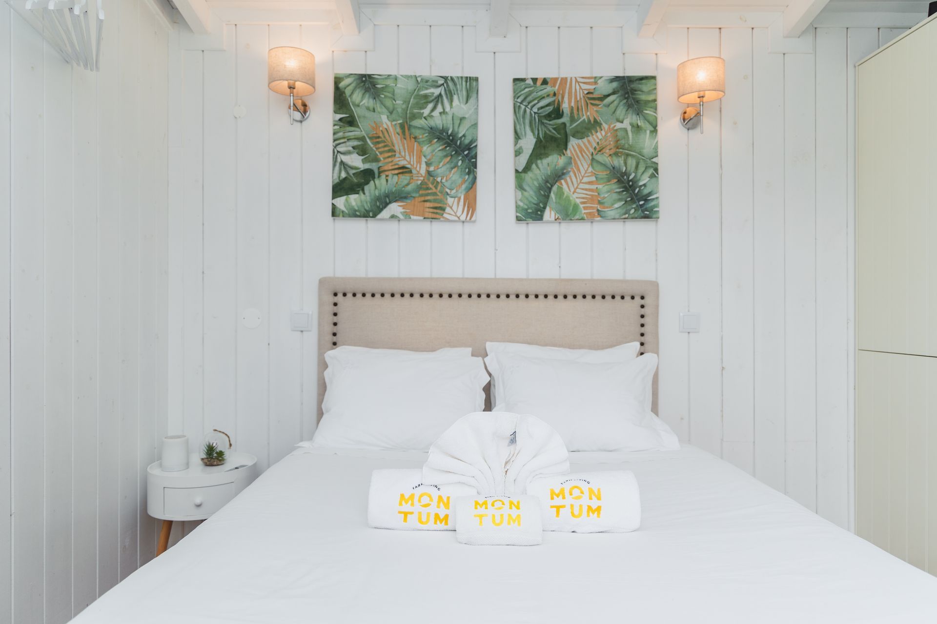 A bedroom with a bed and two paintings on the wall.