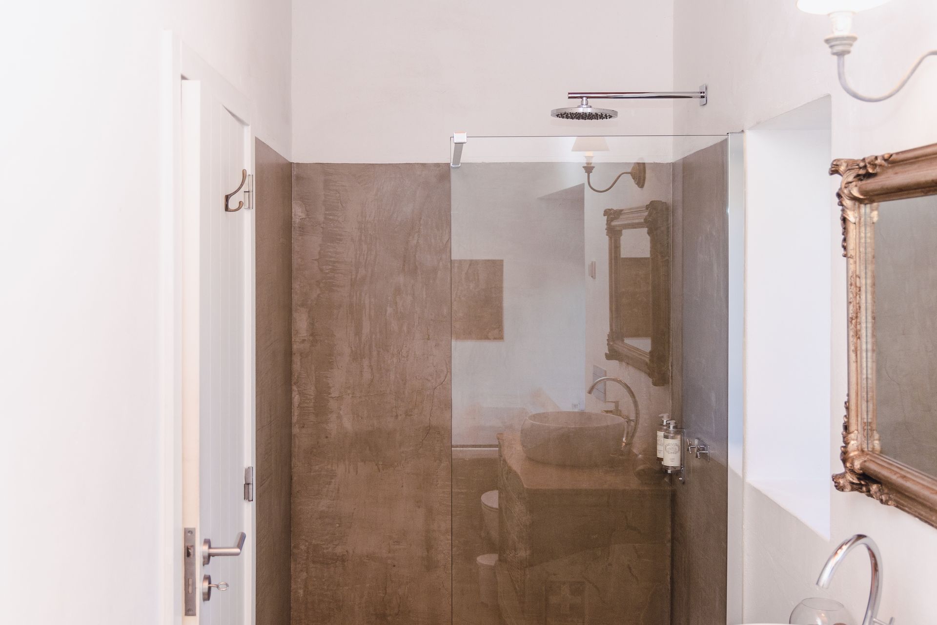 A bathroom with a walk in shower , sink and mirror.