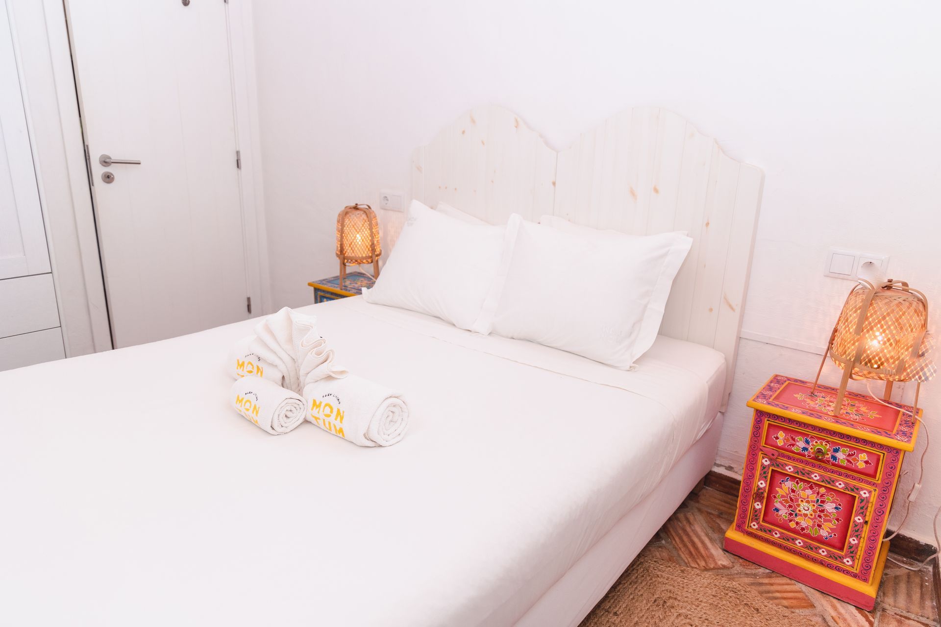 A bedroom with a bed , nightstand , and lamp.