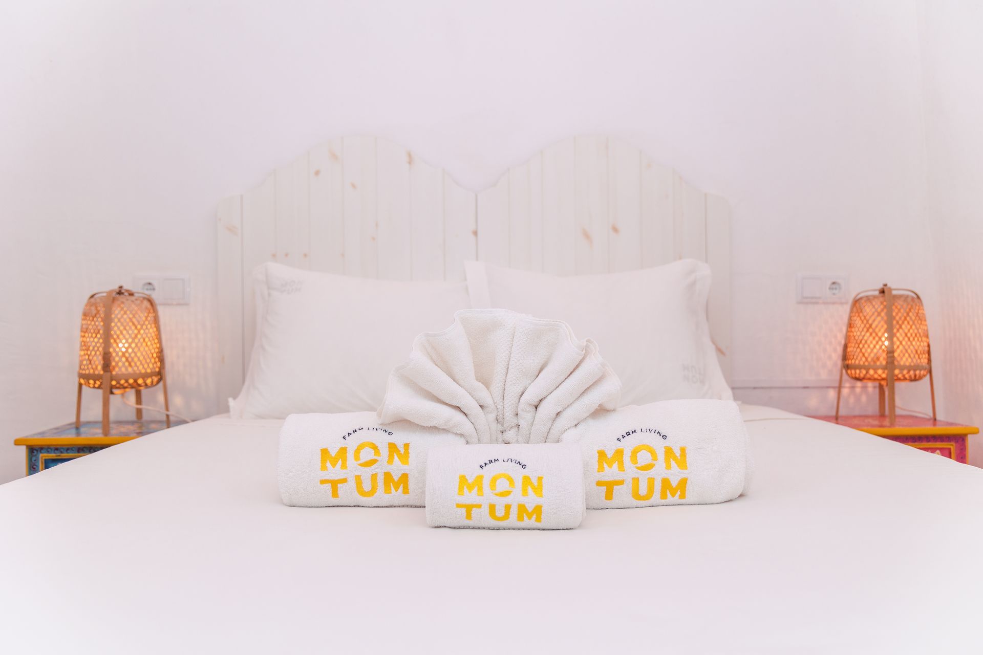 There are three towels on the bed that say mon tum.