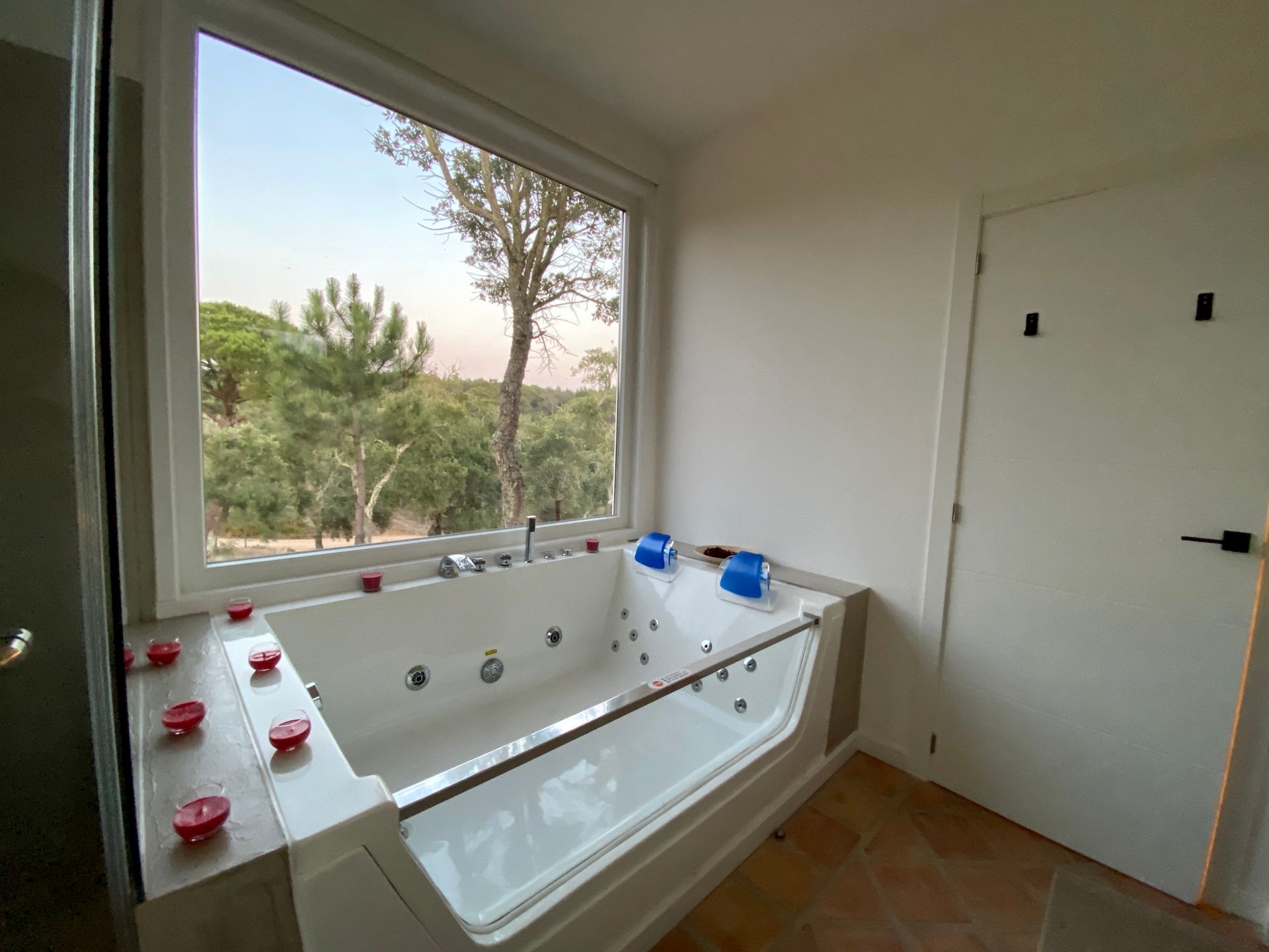 A bathroom with a jacuzzi tub and a window.