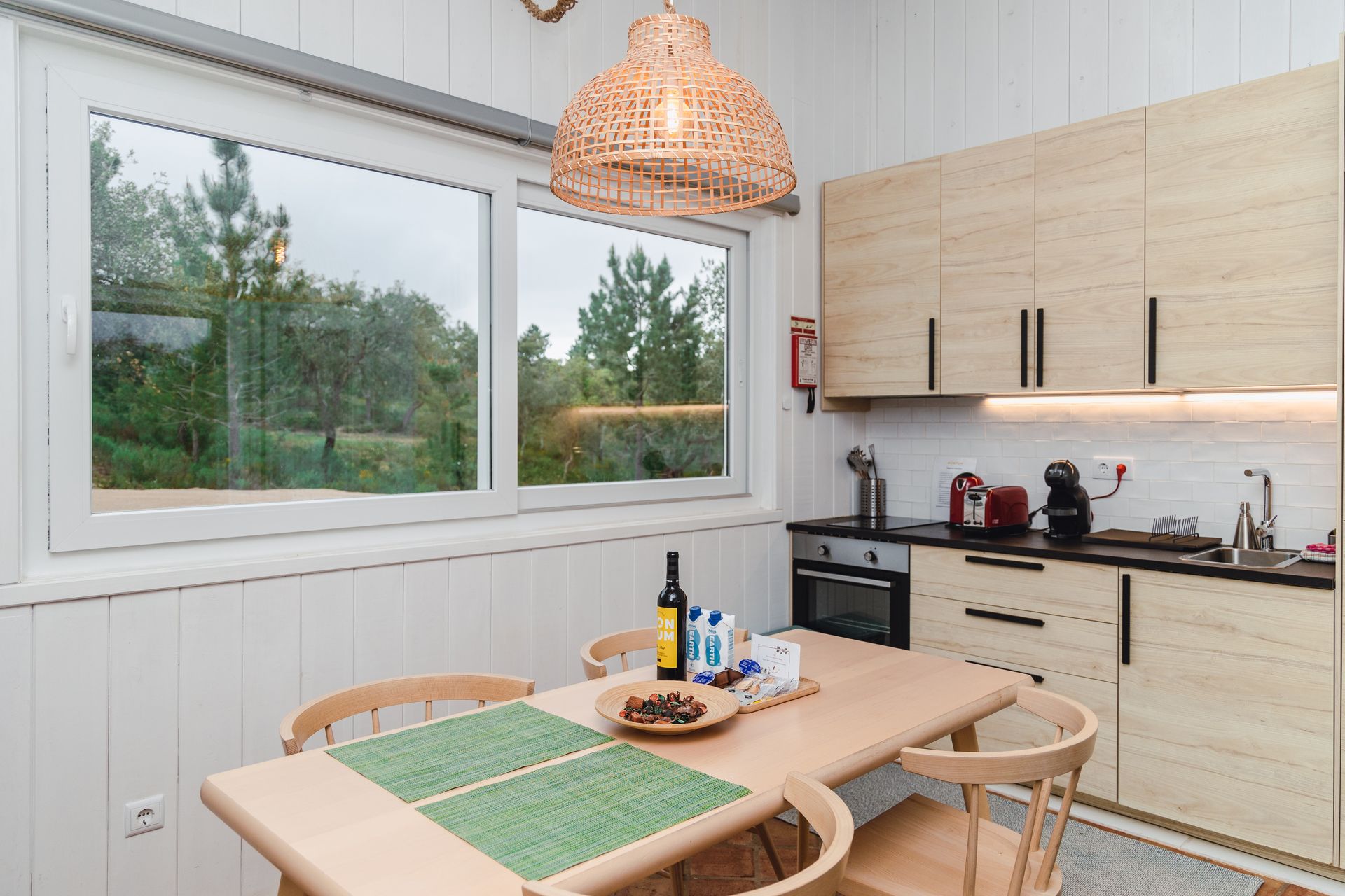 A kitchen with a table and chairs and a large window.
