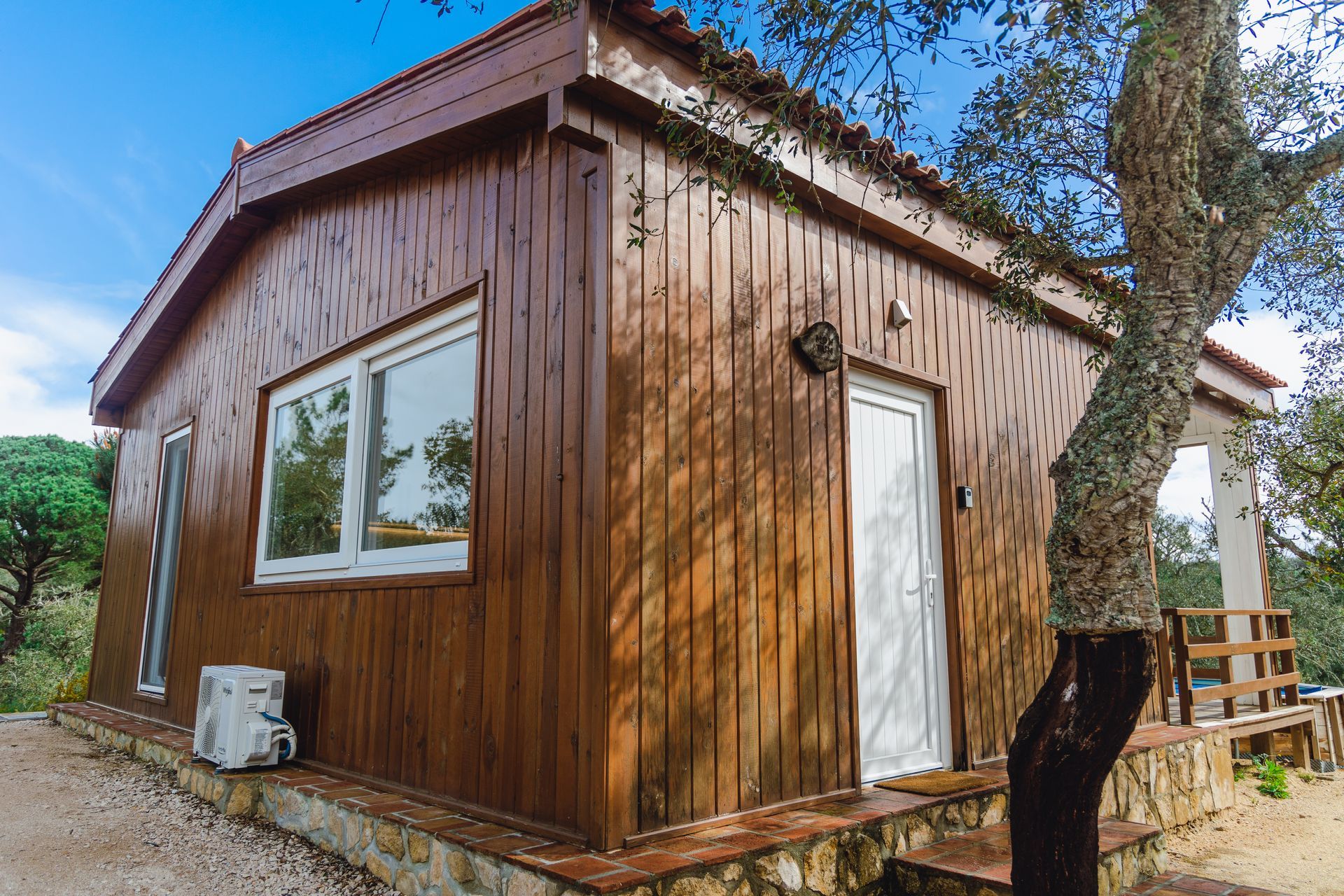 A small wooden house with a tree in front of it.