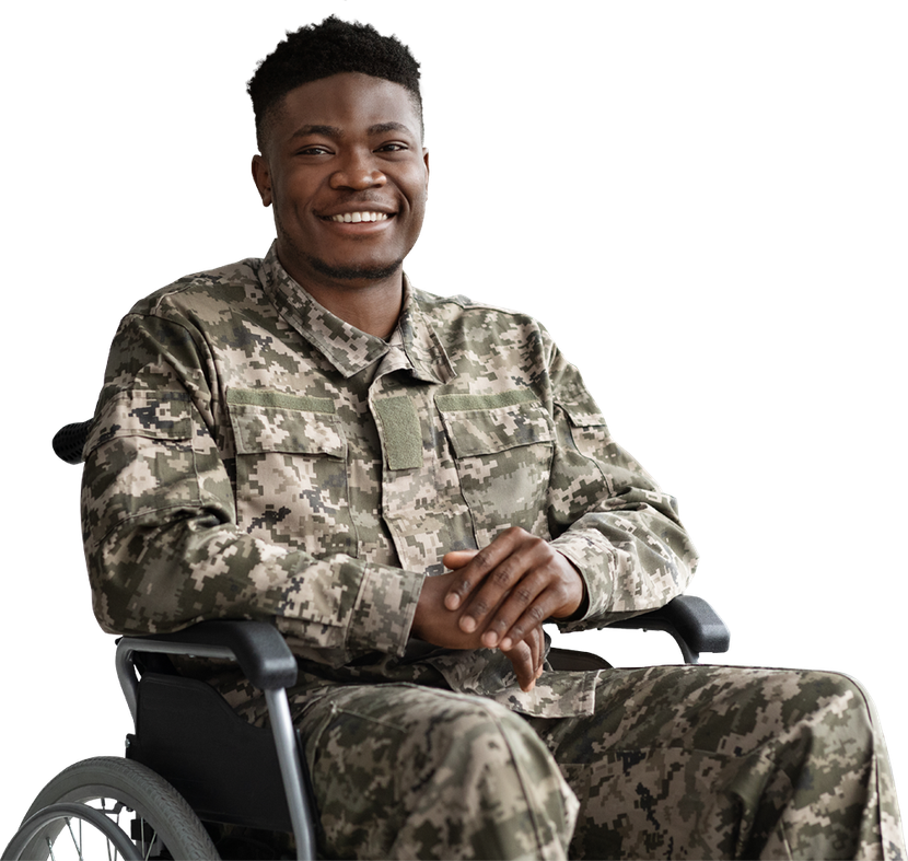 A soldier is sitting in a wheelchair and smiling.