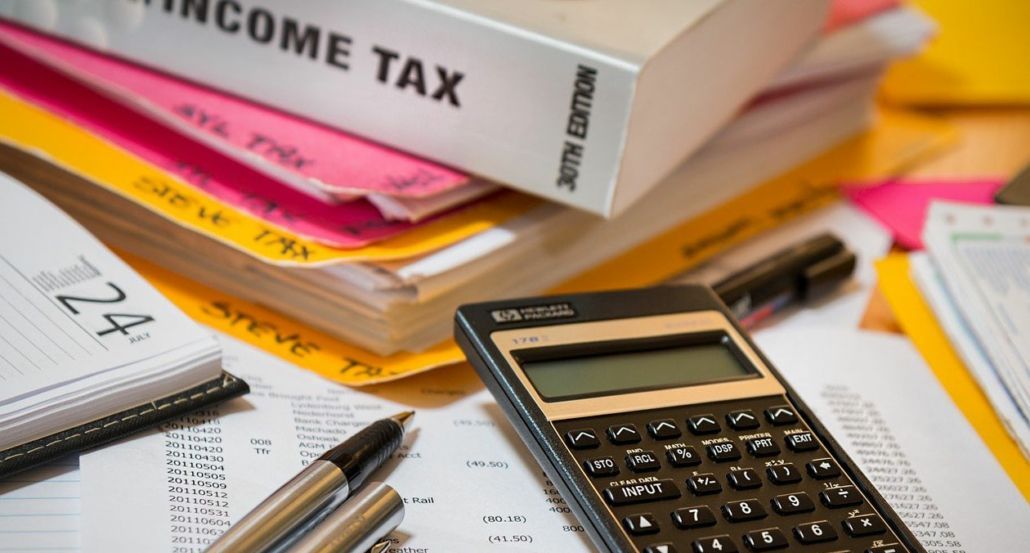 A calculator is sitting on top of a pile of papers.