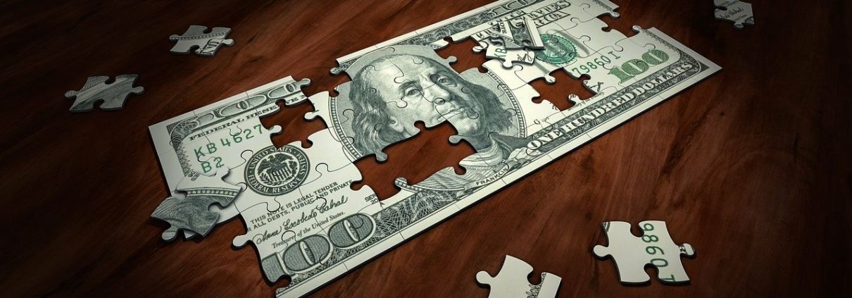 A puzzle of a 100 dollar bill on a wooden table