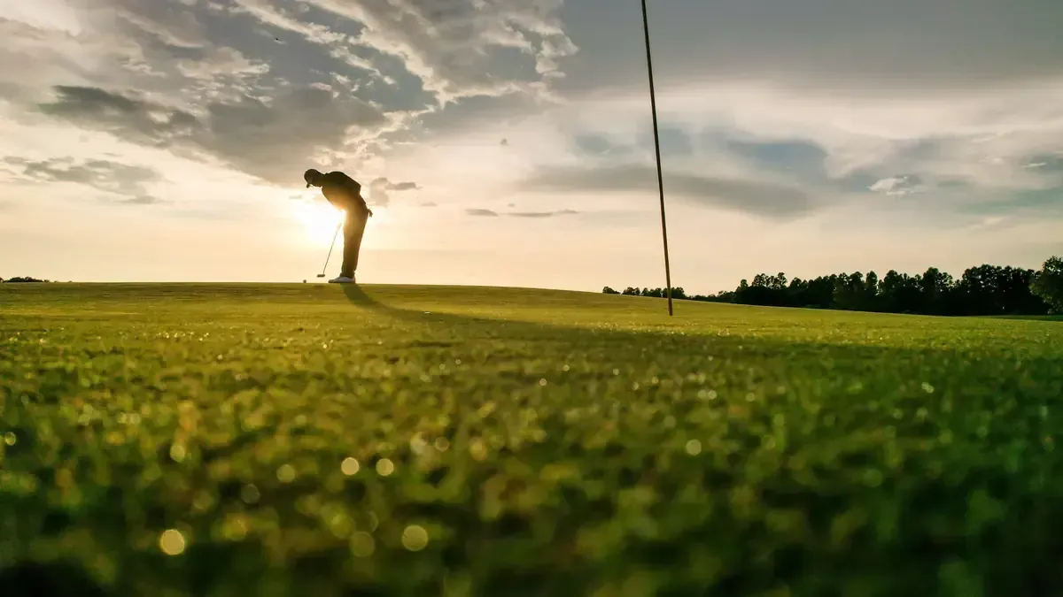 Golfer putting on a sunlit green at sunset — back on the course after non-surgical regenerative treatment