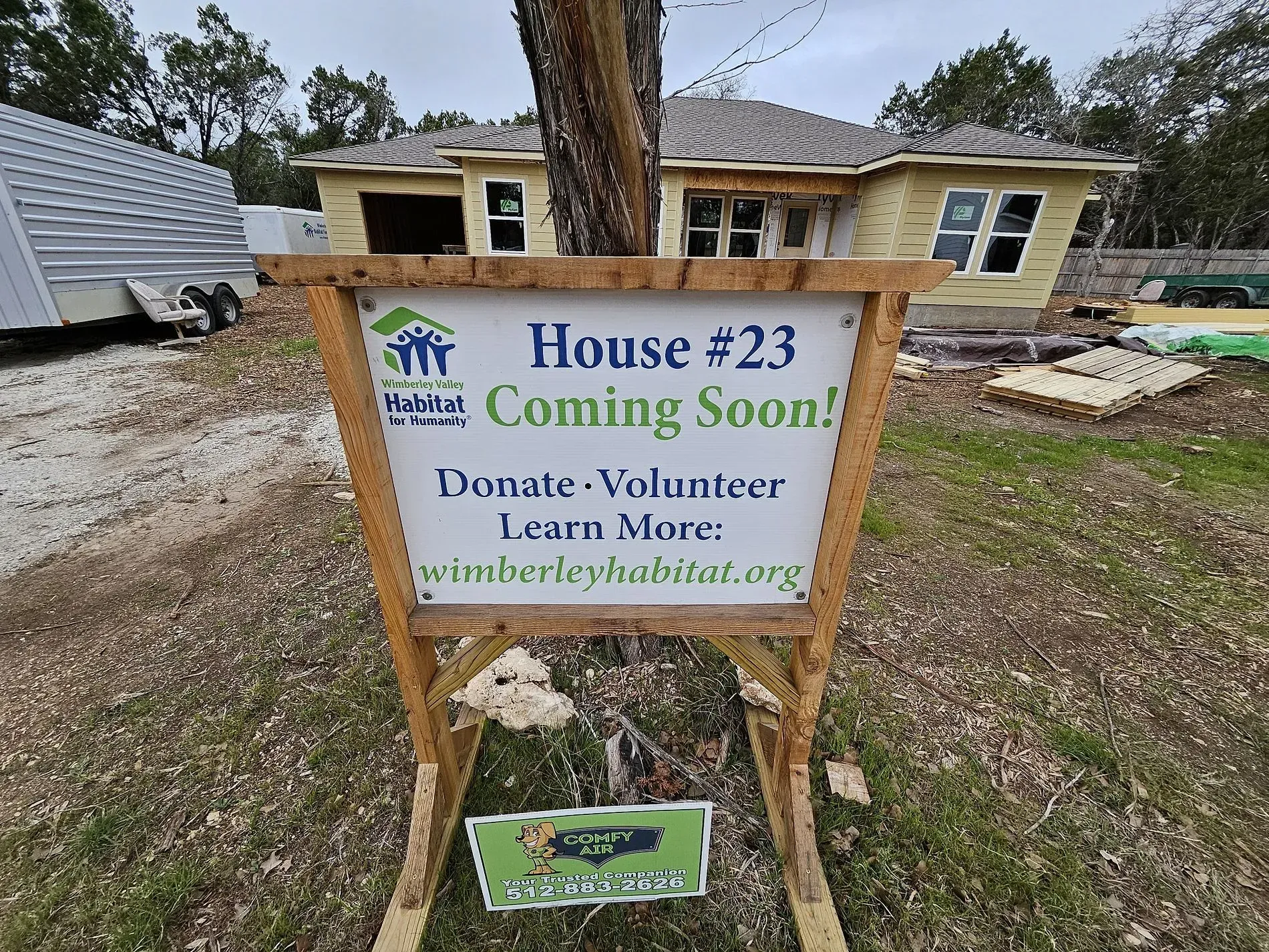 House #23 “Coming Soon” sign in front of a partially built house with a wheelchair-accessible logo