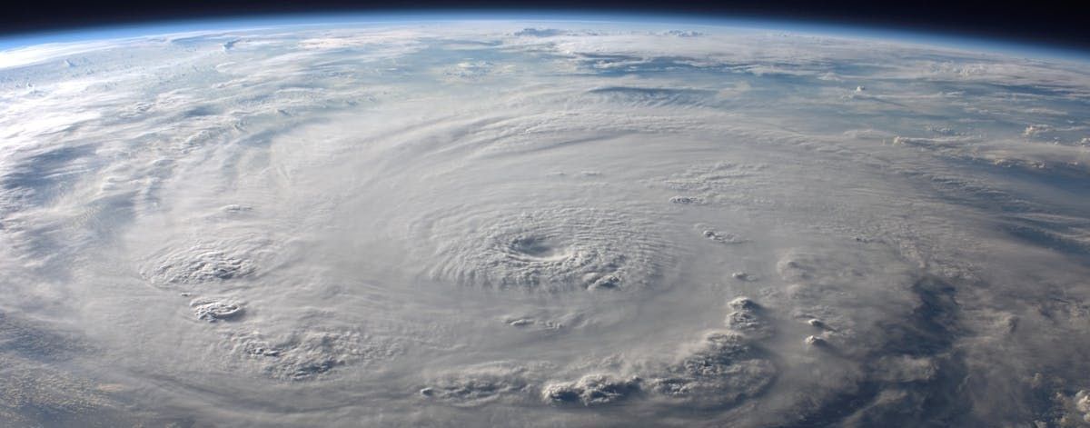Satellite view of a powerful hurricane swirling over the ocean, with a distinct eye and cloud bands