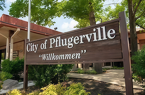 City of Pflugerville welcome sign with “Willkommen” in a green landscaped area